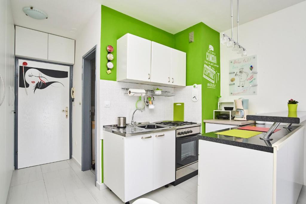 kuchnia z białymi szafkami i zielonymi ścianami w obiekcie Studio Apartment Vanda w mieście Umag