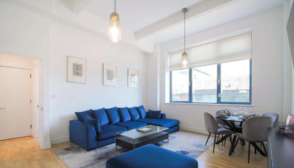 a living room with a blue couch and a table at Large City Centre Apartment Stylish and Spacious in Manchester