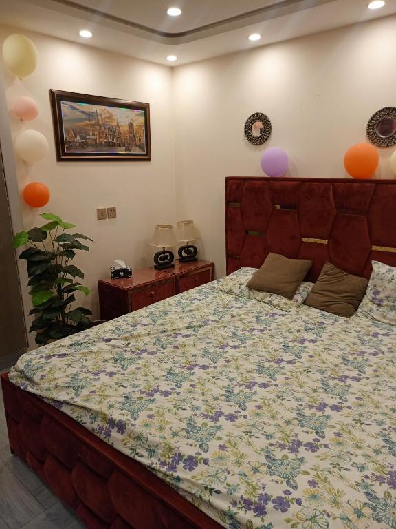a bedroom with a large bed with a floral bedspread at One bed apartment in Lahore in Lahore