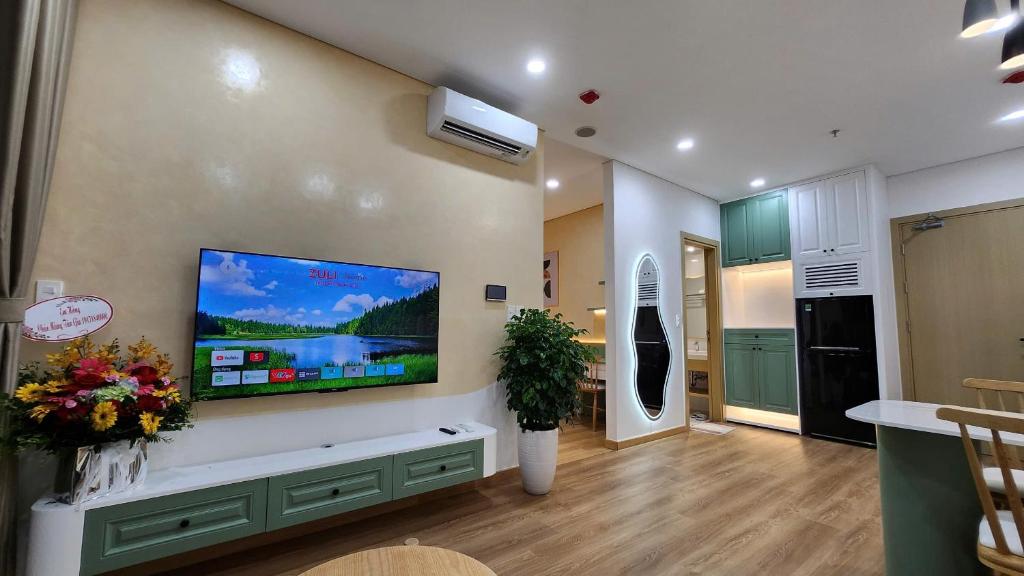 un salon avec une grande télévision à écran plat au mur dans l'établissement Homestay 2PN, 1719 - Chung cư Sentosa Sky Park - Hải Phòng - 2 Bedroom Apartment for Rent, à An Khê