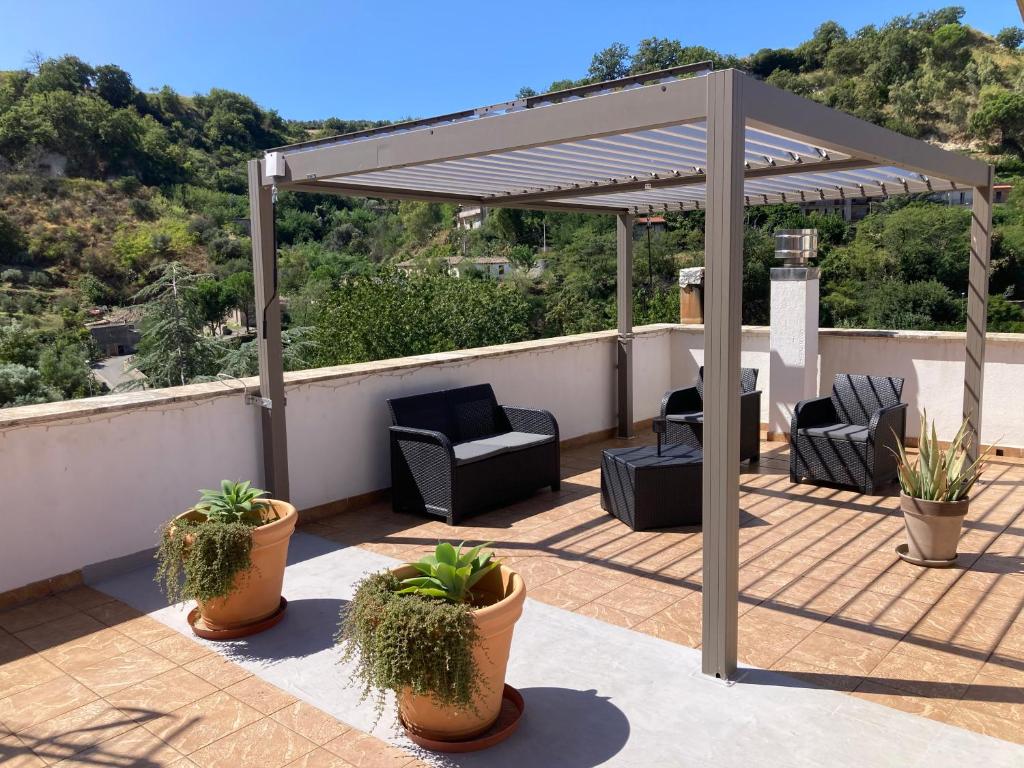 a pergola on a patio with furniture and plants at Casa San Rocco in Guardavalle