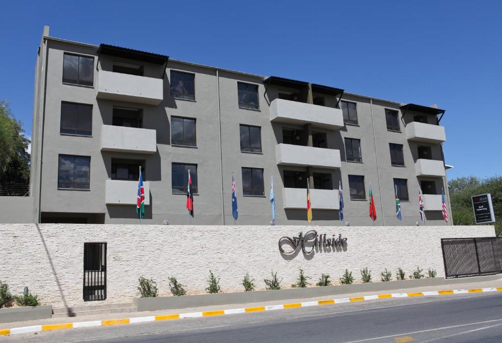 un grand bâtiment avec drapeaux devant lui dans l'établissement Hillside Executive Accommodation, à Windhoek