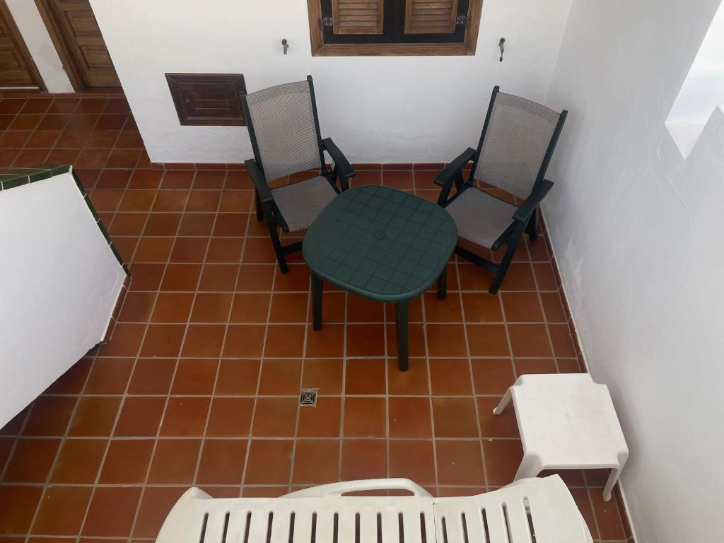 a table and four chairs in a room at Apartamento de 1 dormitorio en Victoria Court 2 Los Cristianos. in Los Cristianos