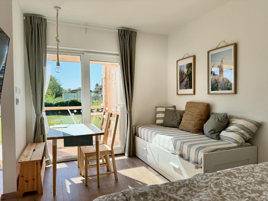 a bedroom with a bed and a table and a window at Tisza-Tavi Nyaralósziget - Just a few steps from the peaceful shores of Lake Tisza in Tiszafüred