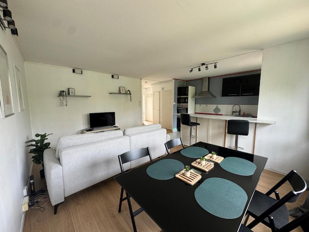 una sala de estar con una mesa y un sofá en Appartement Hérouville, en Hérouville-Saint-Clair