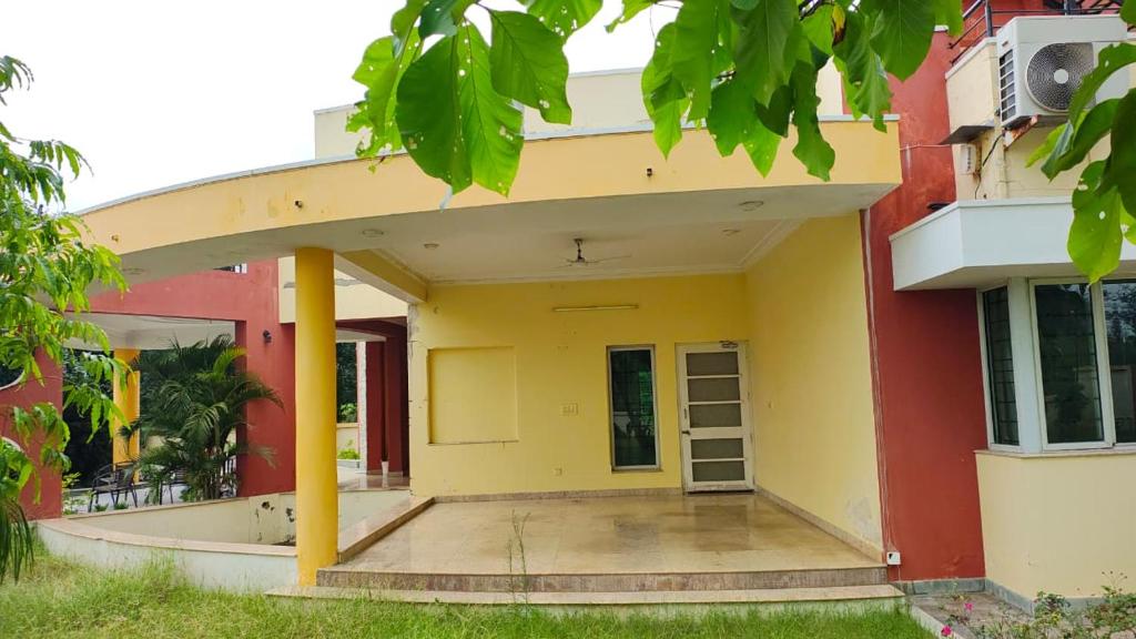 a house with a yellow and red facade at vaibhav farm house in Govindgarh Malkpur
