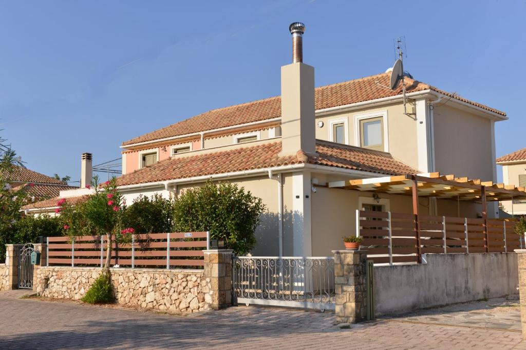 a white house with a fence in front of it at Castello Villa in Kástron