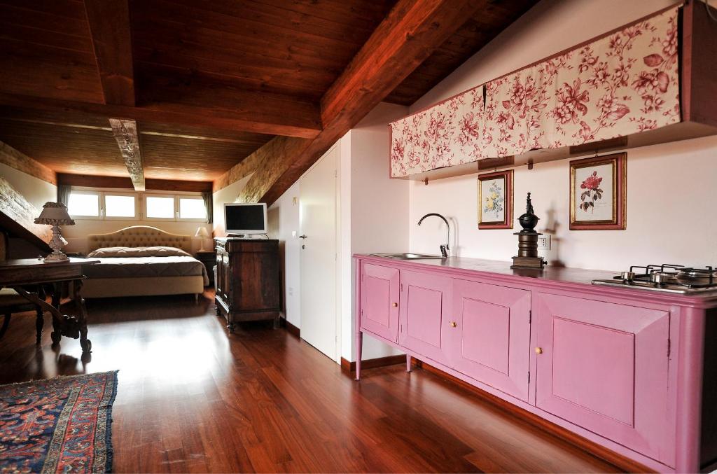 una cocina con una isla rosa en una habitación en B&B Zelmirà, en Rímini