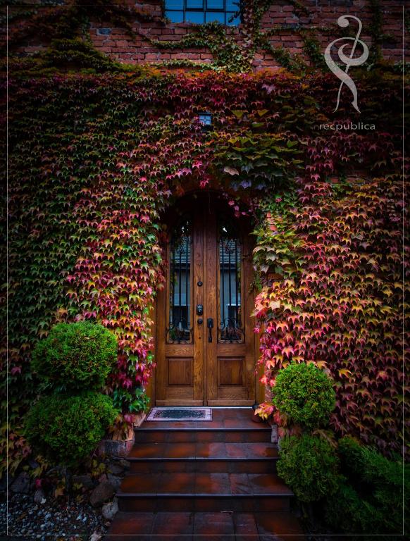 a door in the side of a building with flowers at Miły Młyn in Lubrza