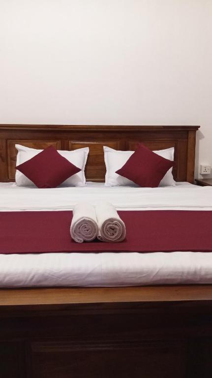 a bed with red and white pillows on it at Ella Sunrise Villa in Ella