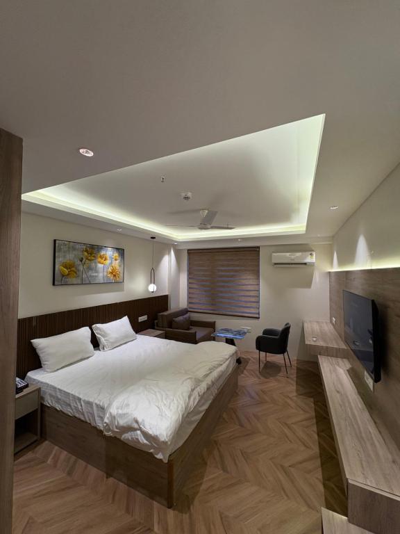 Un dormitorio con una cama y un televisor. en The Sterling twilight, en Greater Noida