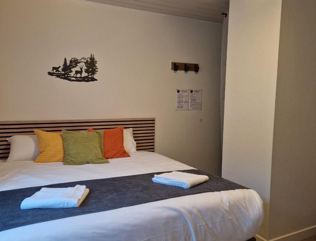 a bedroom with a bed with two towels on it at Hôtel du Centre - Restaurant Lelex'ir in Lélex