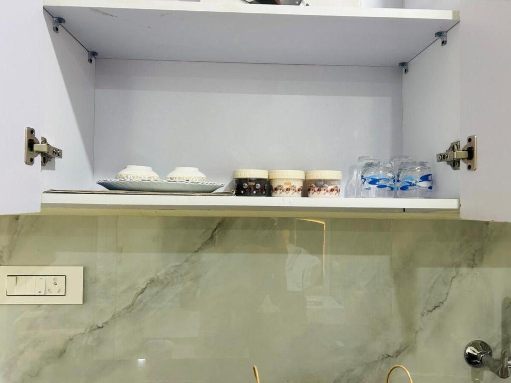 a shelf with bowls and plates on it in a room at Ansh Abode Retreat in Zirakpur