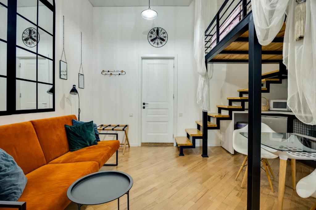 a living room with a couch and a staircase at Freedom Square - Poets' Nest in Tbilisi City