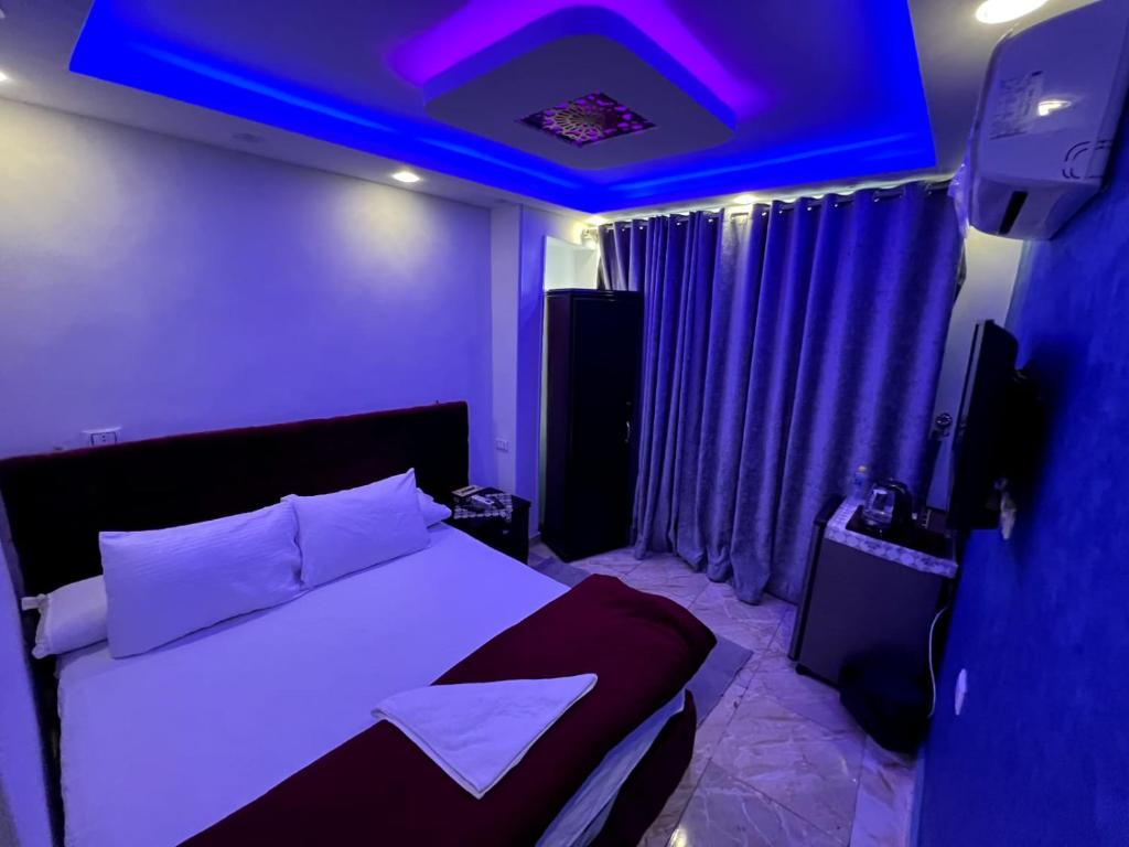 a bedroom with a bed with a purple ceiling at arwa pyramids view in Cairo
