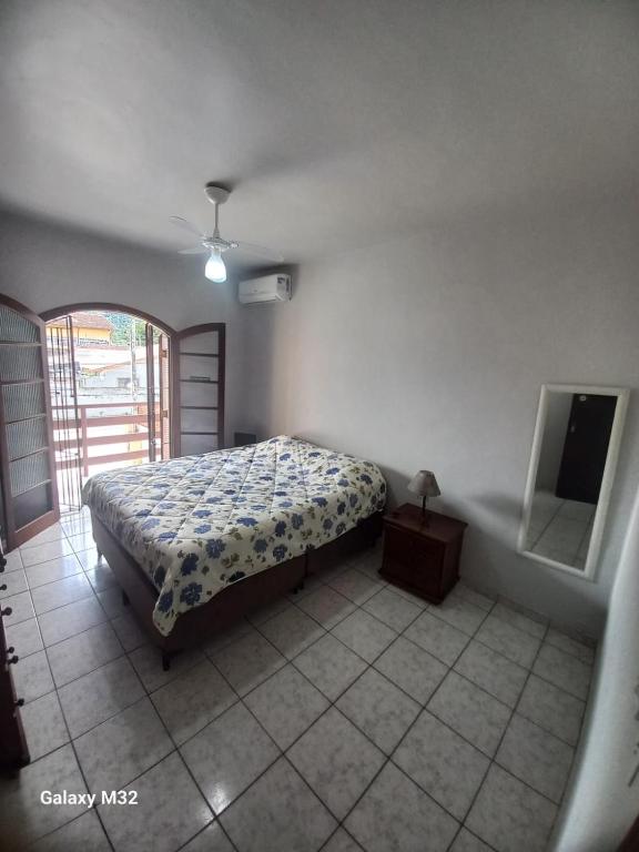 a bedroom with a bed and a mirror in it at Casa de Praia in Ubatuba