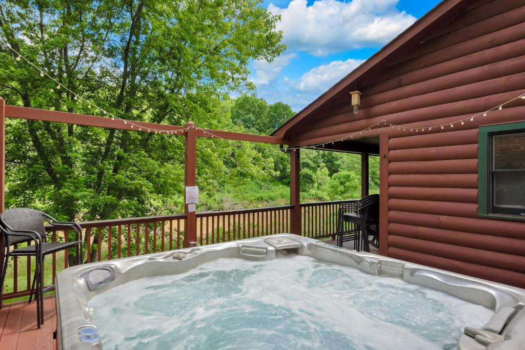 a hot tub on the deck of a house at 30 Mins to Boone, Fire Pit, Hot Tub, 3 porches, Dogs OK in Brownwood