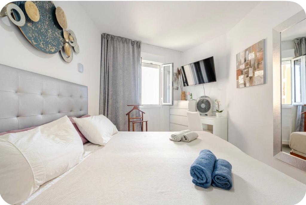 een slaapkamer met een bed met twee blauwe handdoeken erop bij Exclusive ocean front apartment in Playa de las Americas