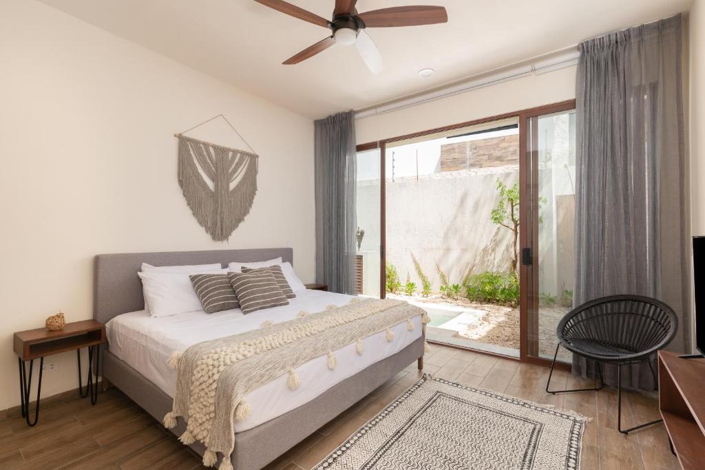 a bedroom with a bed and a ceiling fan at UTSKIN By ZENDA - Luxury Villas & Private Pools in Tulum