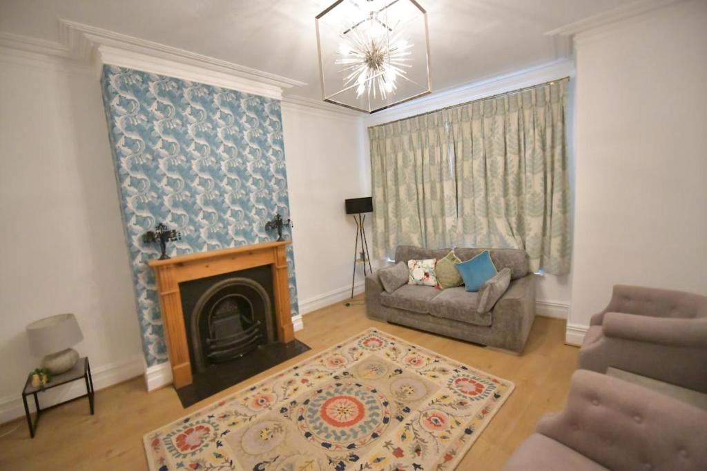 a living room with a couch and a fireplace at Charming & Cosy Home Stockport in Stockport