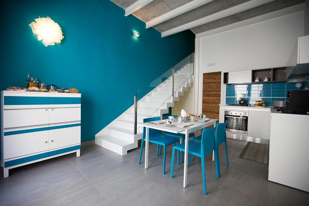 una cocina con mesa y sillas y una escalera en B&B Kolors, en Castellammare del Golfo