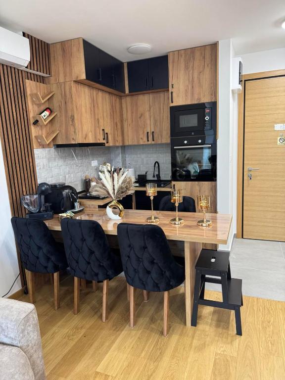 a kitchen with a wooden table and chairs at WOLF apartman in Divčibare