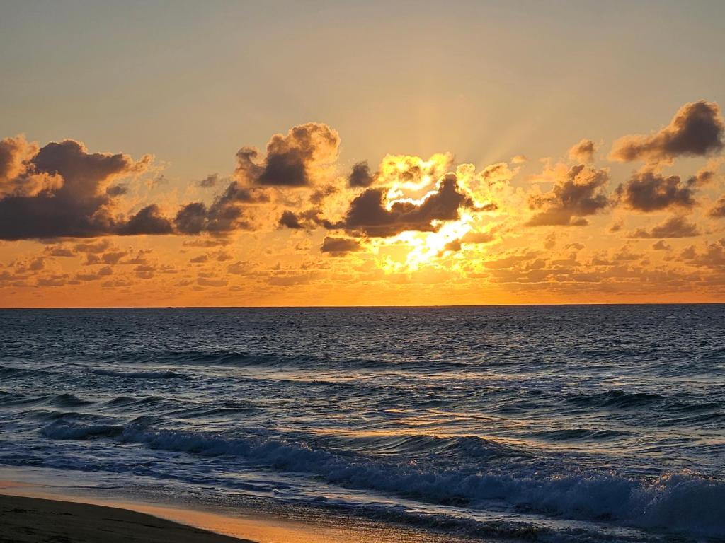 a sunset over the ocean with the sun setting at Pelican Dock Apartments in Aguada