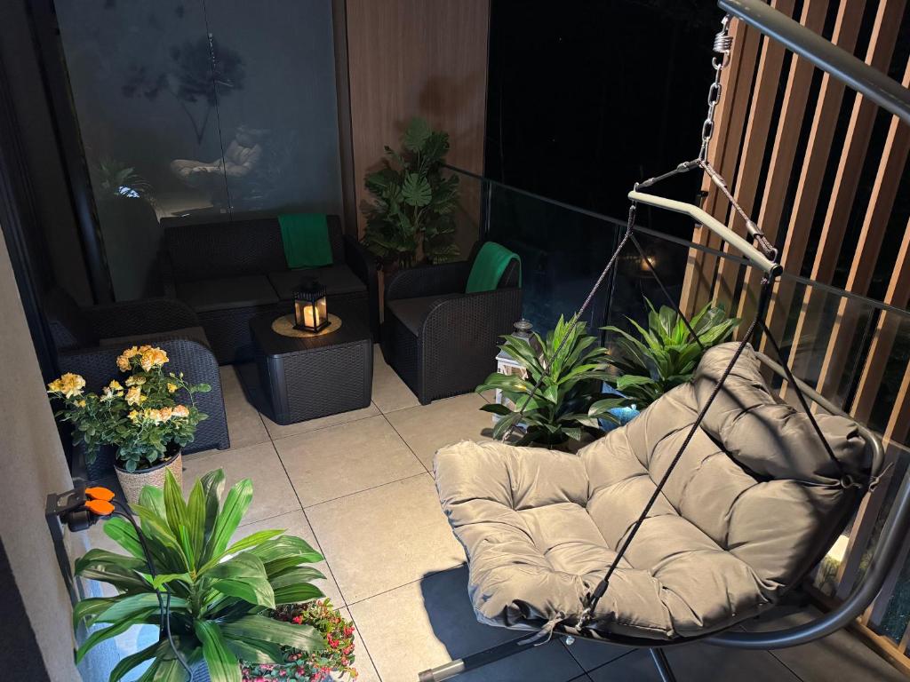 a chair sitting on a balcony with plants at Apartament Virgo in Międzyzdroje