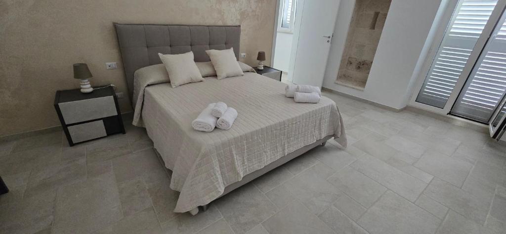 a bedroom with a bed with two towels on it at Bellini Holiday House in Mola di Bari