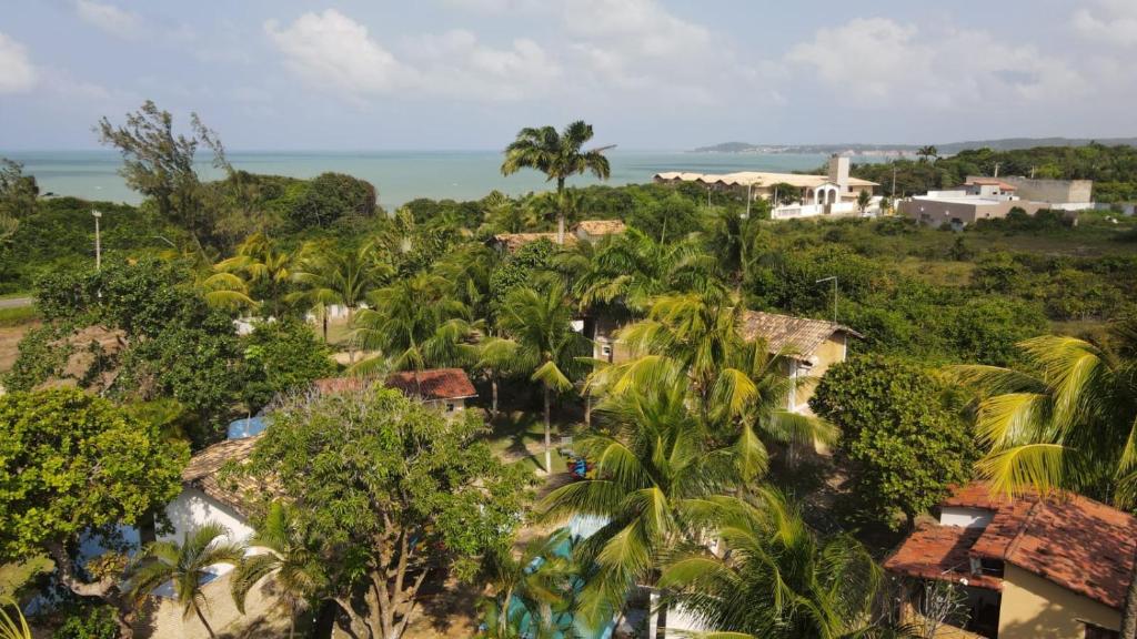an aerial view of a resort with palm trees and the ocean at Pousada Cacimbinha in Pipa