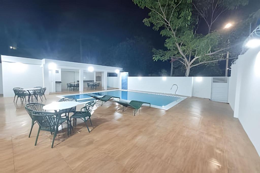 a swimming pool with tables and chairs in a room at Villa do Porto Resindece in Porto De Galinhas