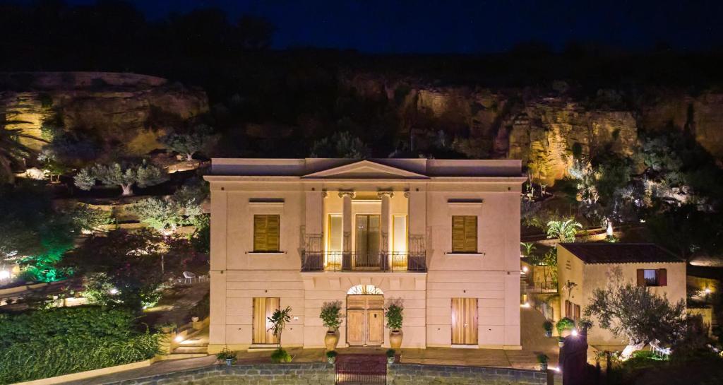 a house at night with a mountain in the background at Villa Cavetta in Agrigento
