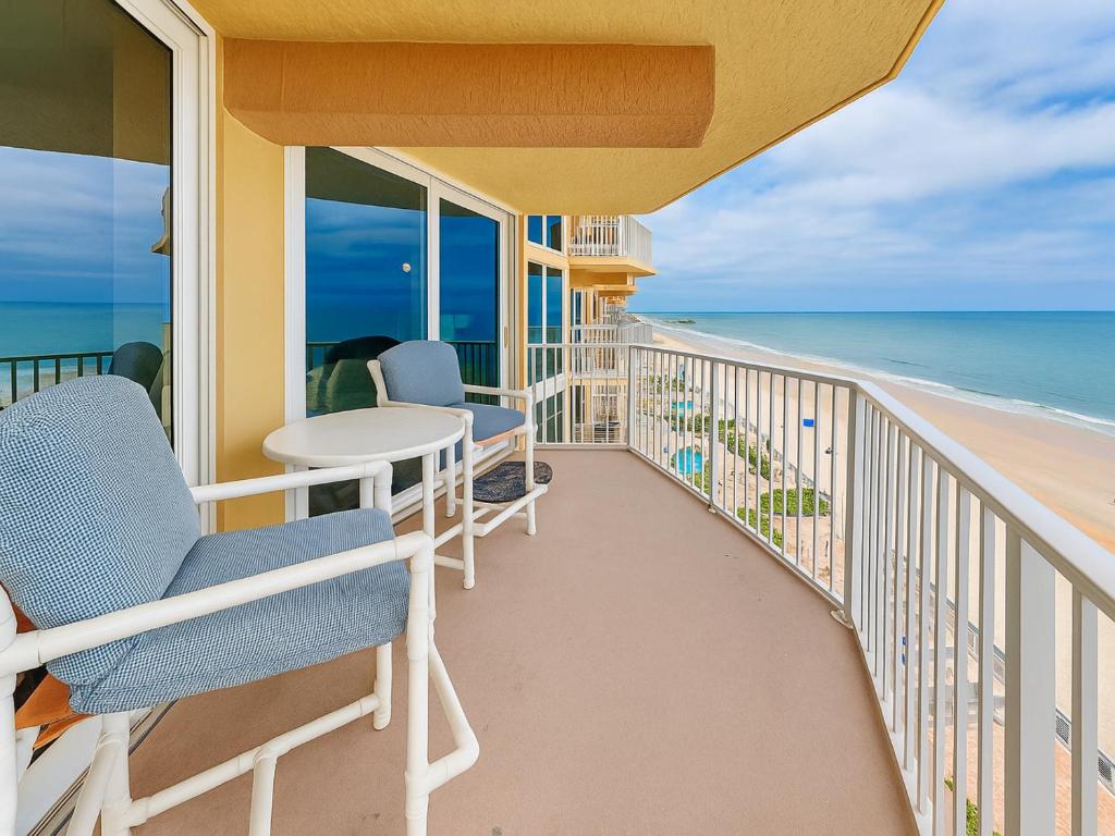 a balcony with chairs and a table and the ocean at Shores Club 703 in Daytona Beach