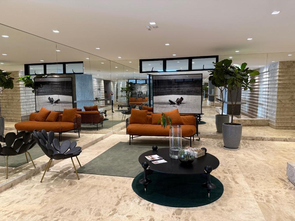 a lobby with orange couches and a table at Apt 1 Quarto Luxuoso - Gyro Vaca Brava in Goiânia