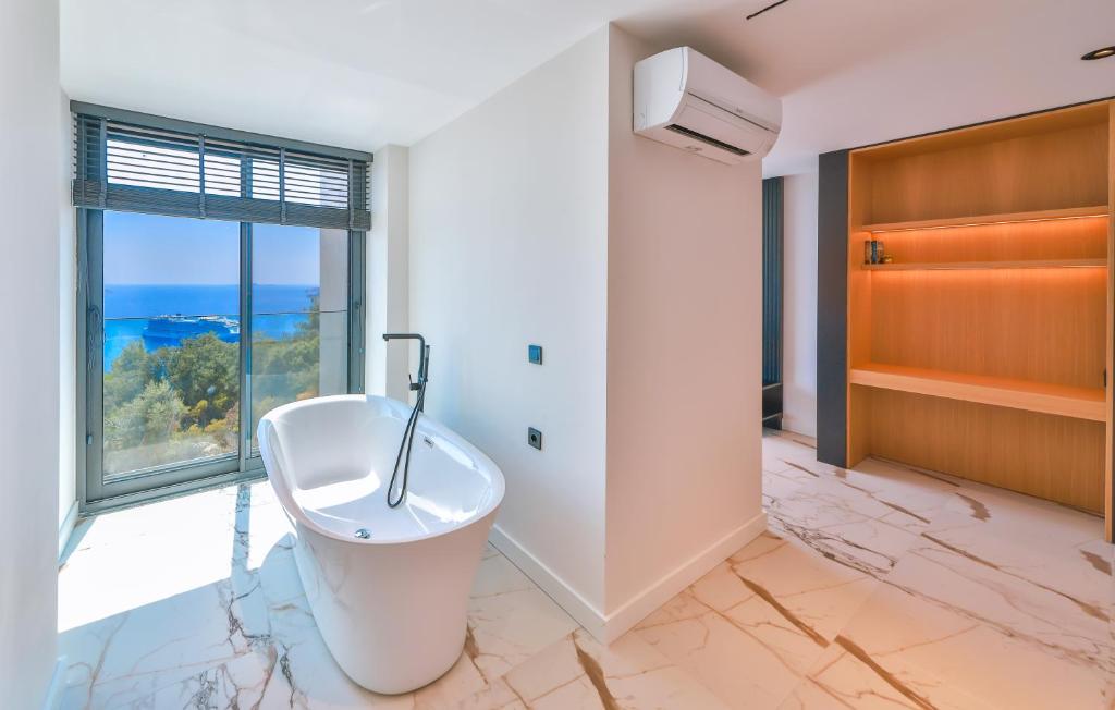 a bathroom with a white tub and a window at Villa Maresolia in Kas