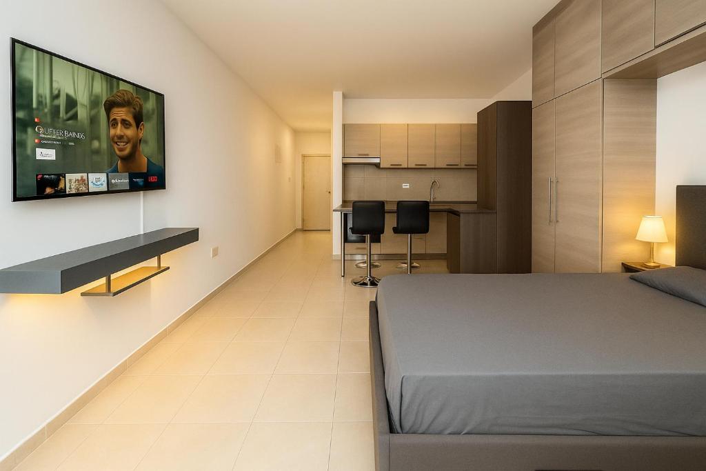 a bedroom with a bed and a flat screen tv on a wall at Maison Amalthea in Limassol