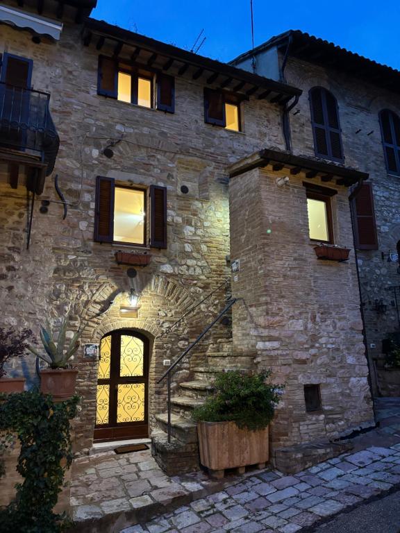 a stone building with a door in front of it at Torretta dependance in Assisi