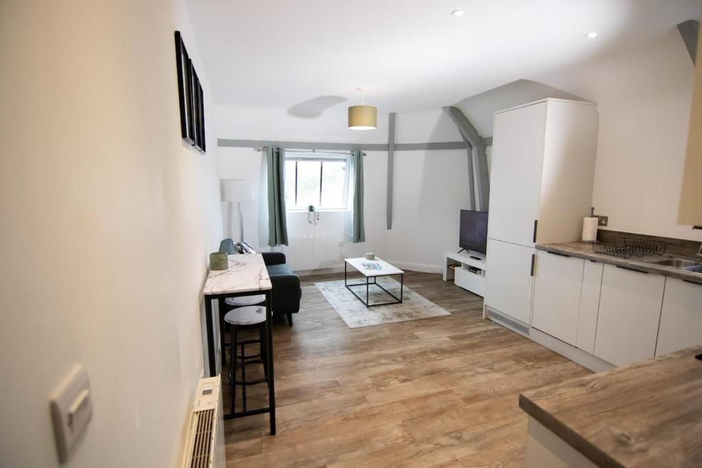 a kitchen and a living room with a table in a room at Stylish, Spacious 1 Bedroom Apartment, central in Bristol