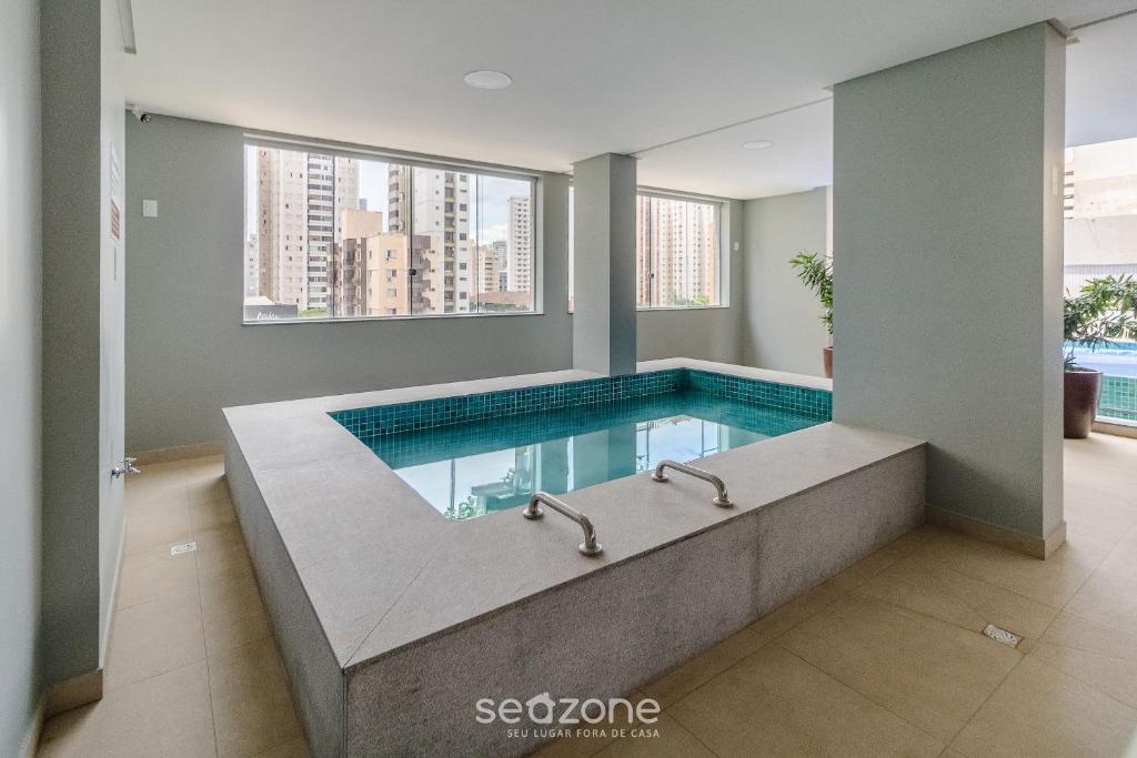 a swimming pool with a tub in a building at RBN - Apartamentos no Ritmo Bueno in Goiânia