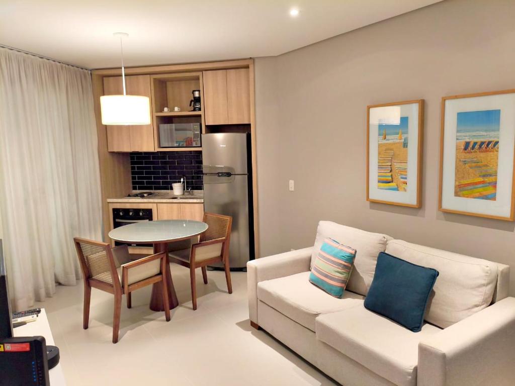 a living room with a white couch and a table at Estanconfor Santos - vista mar in Santos