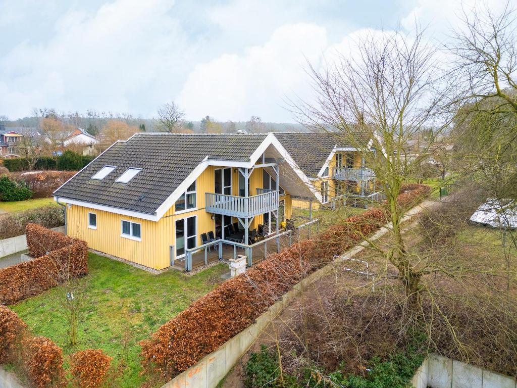 a yellow house with a black roof on a yard at Ferienhaus ideal für Familien in Granzow
