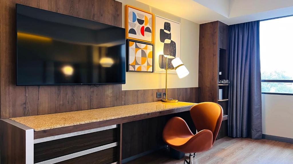 A wall-mounted television and long desk create a practical work-and-entertainment wall.