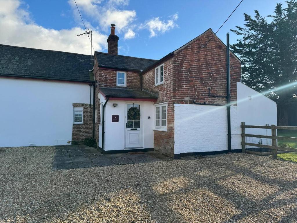 a house with a white garage and a brick building at New Close Farmhouse in Bransgore