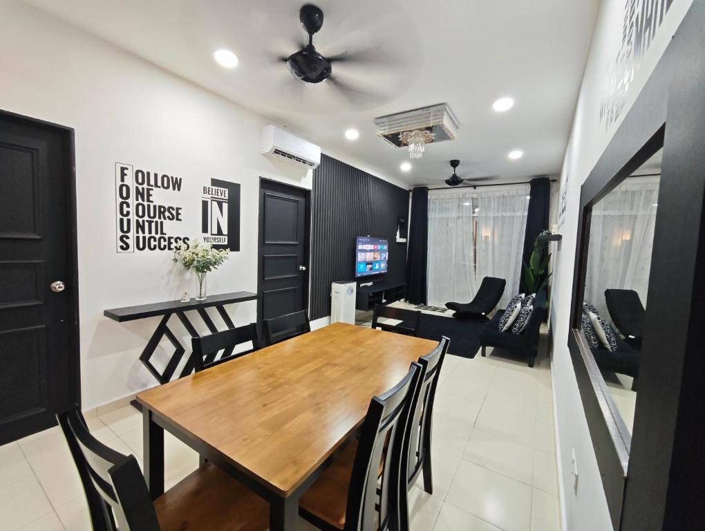 a dining room and living room with a wooden table and chairs at Carissa Homestay Kuantan in Kuantan