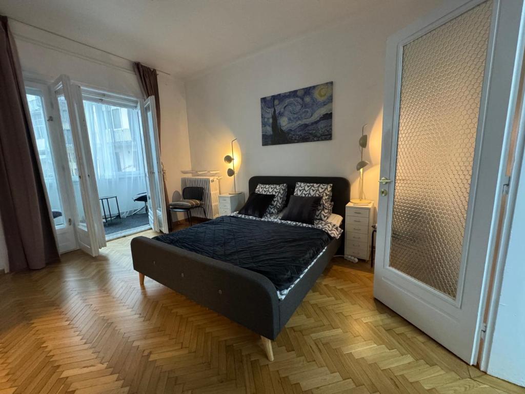ein Schlafzimmer mit einem schwarzen Bett in einem Zimmer in der Unterkunft Airy & Beautiful Downtown Apartment in Bukarest
