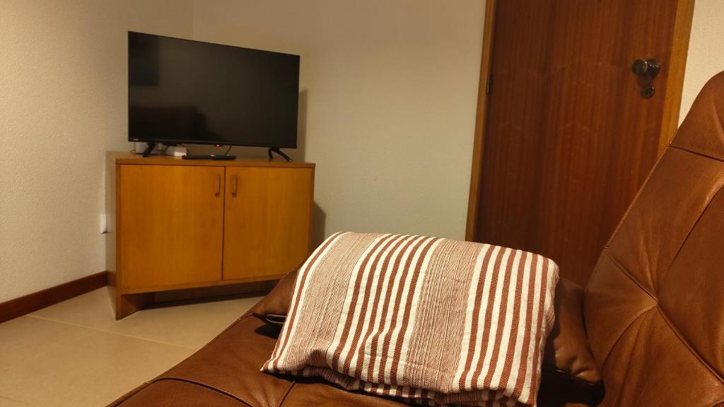 a living room with a tv and a couch with a blanket at Sol II in Funchal
