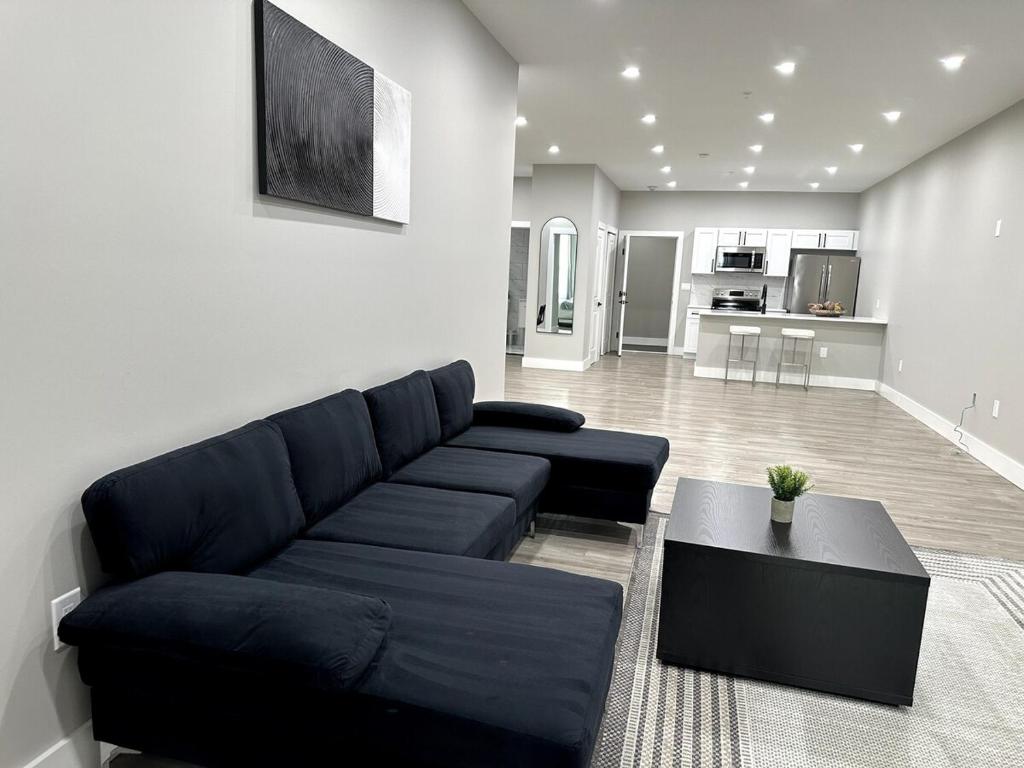 a living room with a blue couch and a table at Spacious Modern 1 Bedroom RARE Apt w GYM in Albany