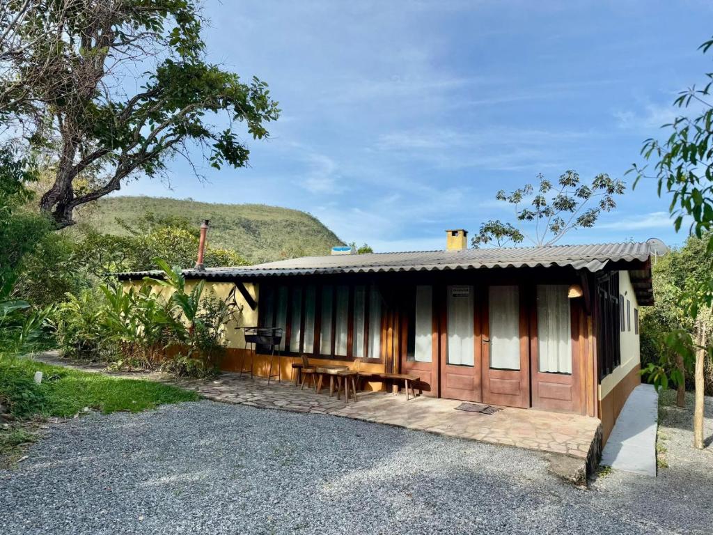 eine Hütte mit einem Tisch und Bänken davor in der Unterkunft Pousada Loquinhas in Alto Paraíso de Goiás