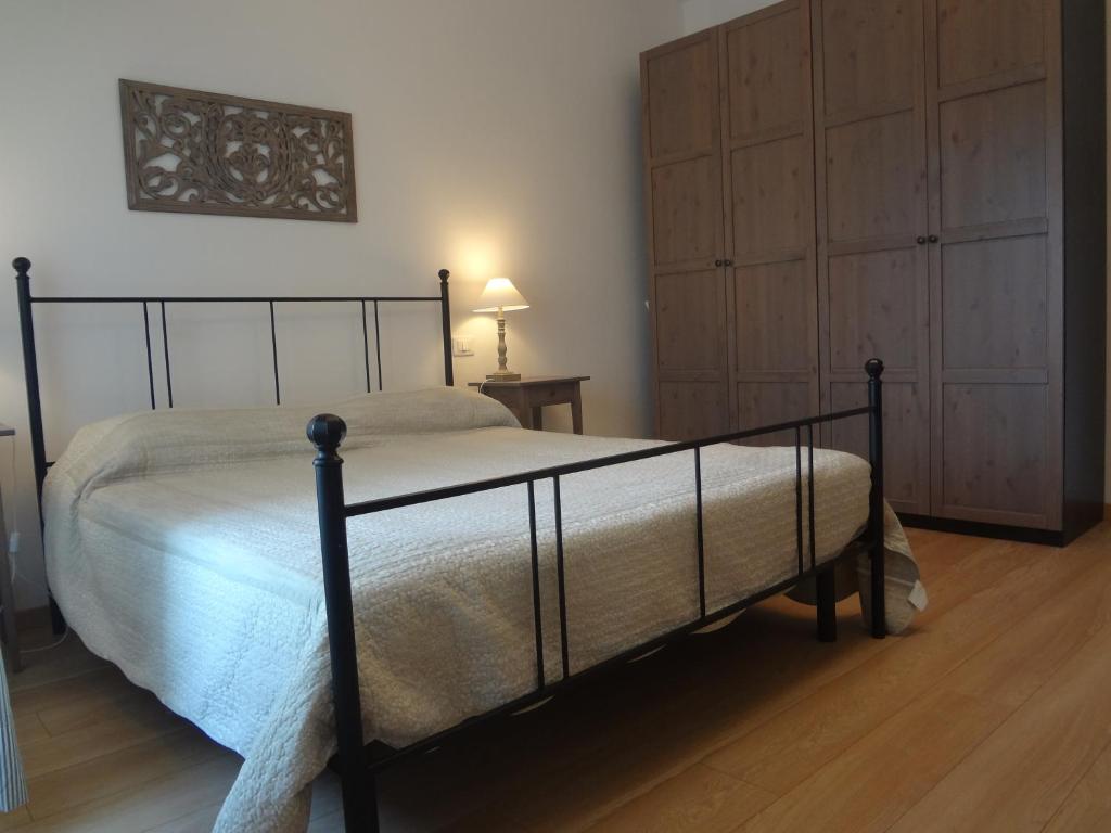 a bedroom with a black bed and a wooden floor at La Pineta Apartment in Viareggio