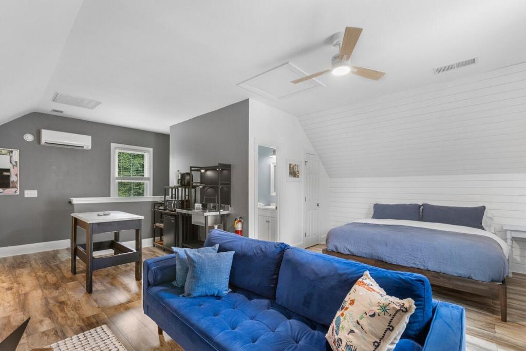 チャールストンにあるCharming Chic Charleston & DI Loft Getawayの青いソファとベッドのあるリビングルーム